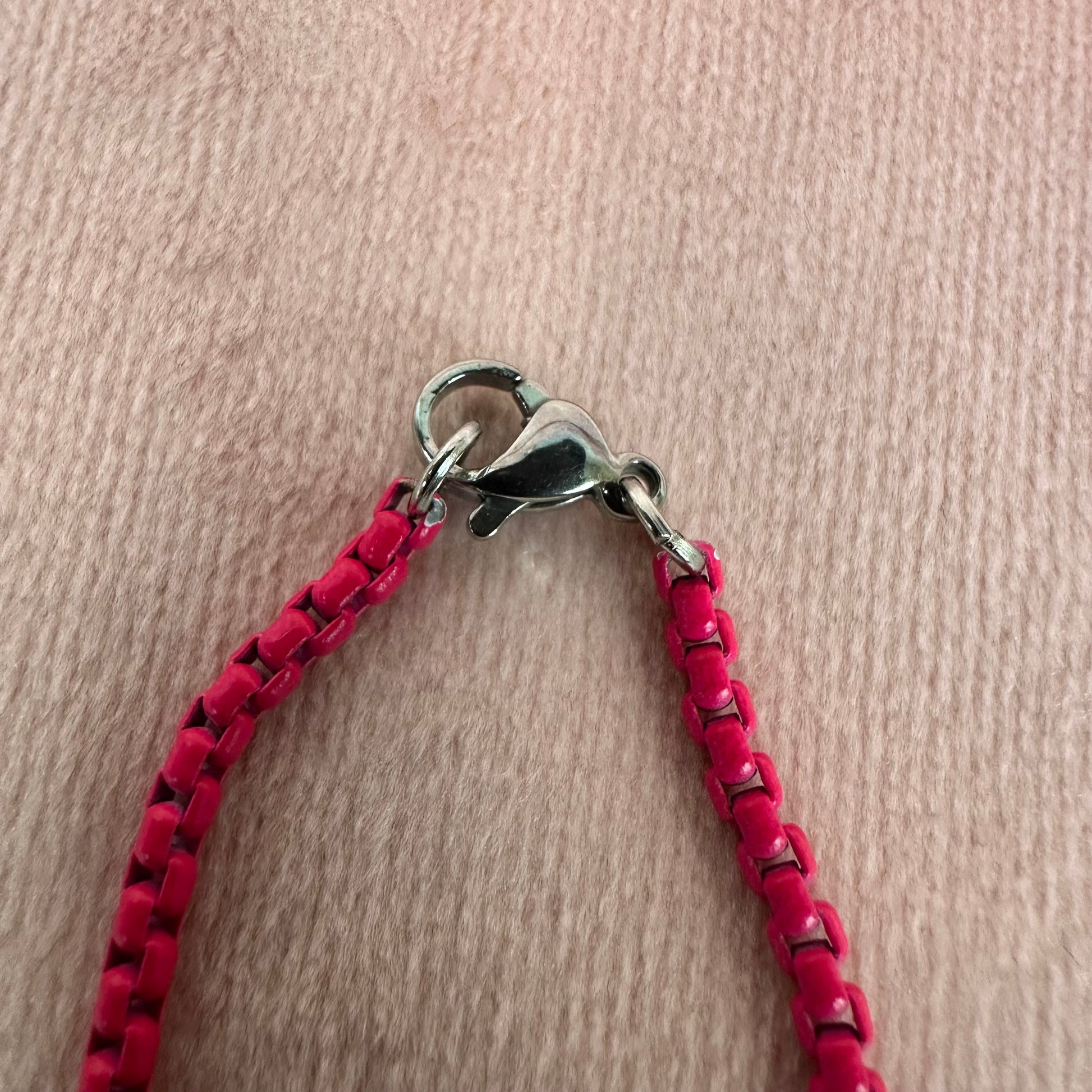 close up of pink enamel chain clasp
